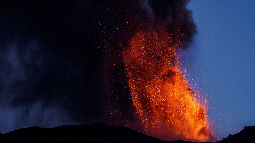 Lava e nuvens de fumo sobem de uma cratera do Vulcão Etna , o vulcão mais ativo da Europa