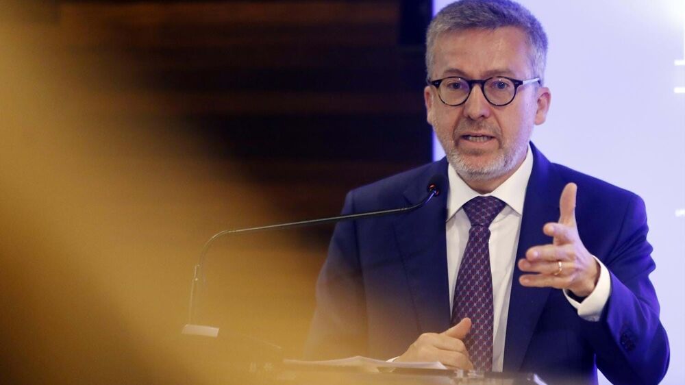 Político discursa ao microfone num evento formal