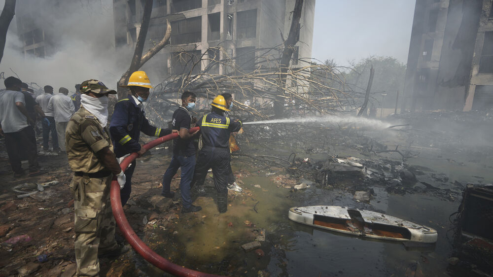 Equipes de emergência combatem incêndio após queda de avião na Índia