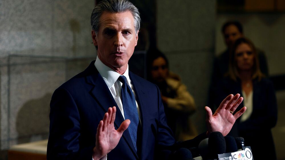 Gavin Newsom discursa com microfones à frente