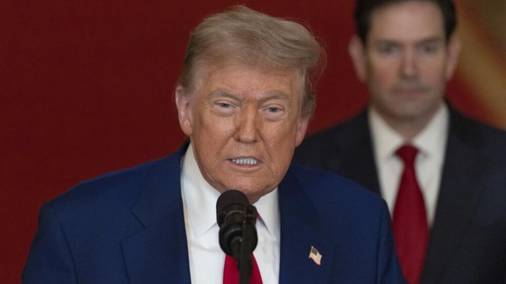 Donald Trump discursa ao microfone com Marco Rubio ao fundo