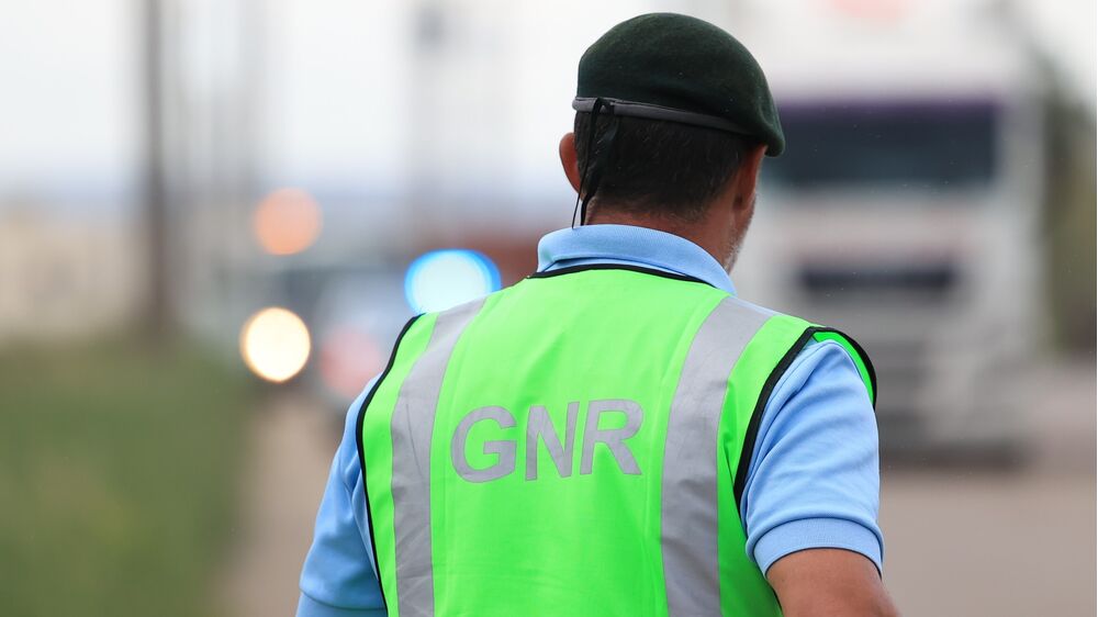 Agente da GNR de costas, com colete reflector e boina verde