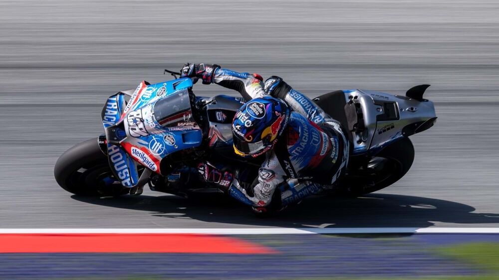 Piloto em corrida de MotoGP com a mota inclinada numa curva