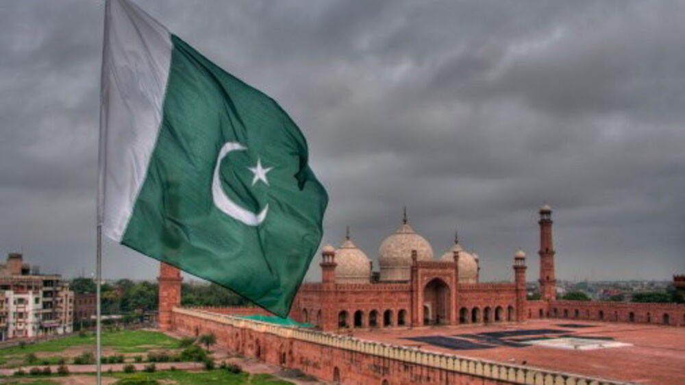 Bandeira do Paquistão em Lahore com a mesquita Badshahi ao fundo