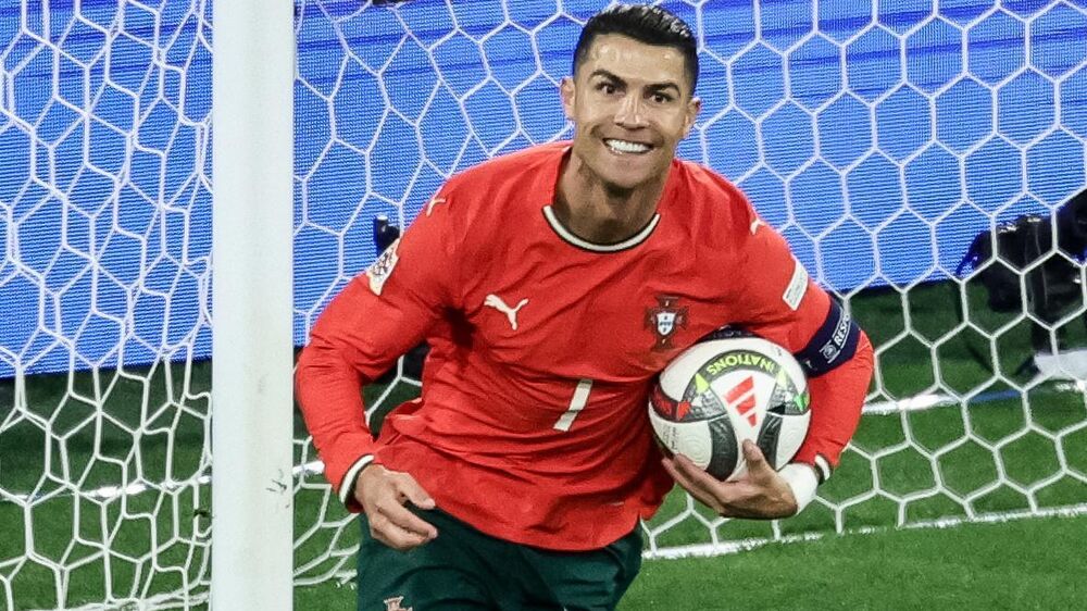 Cristiano Ronaldo sorri com a bola na mão