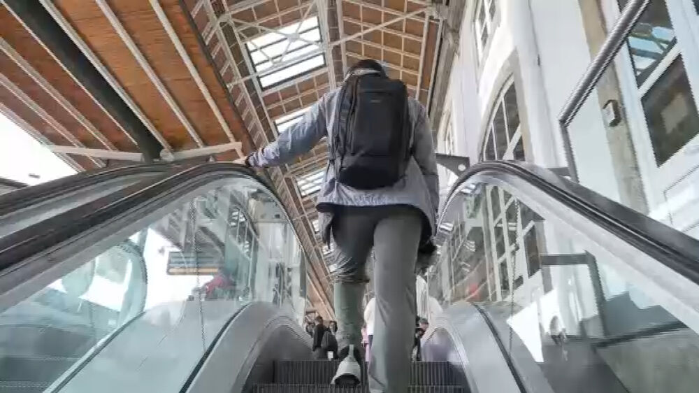 Passageiro usa escada rolante na estação de comboios de São Bento, no Porto