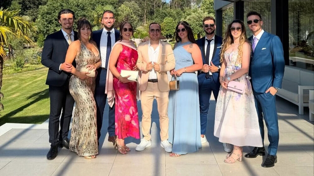 Grupo de pessoas elegantes posa para foto num evento especial ao ar livre