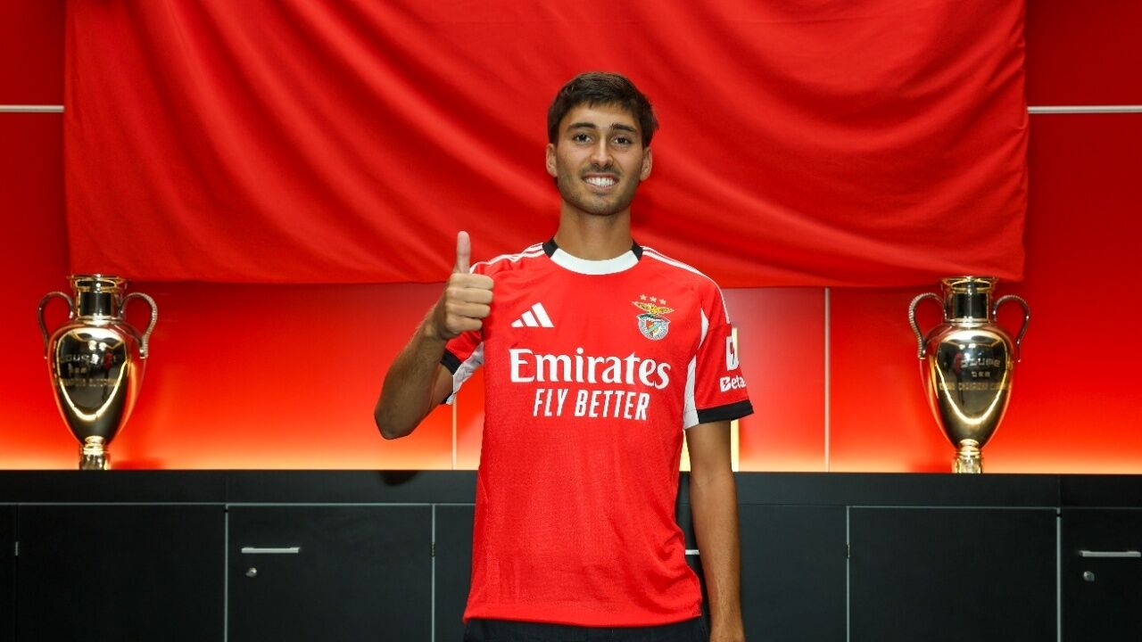 Jogador do Benfica faz sinal positivo junto a troféus