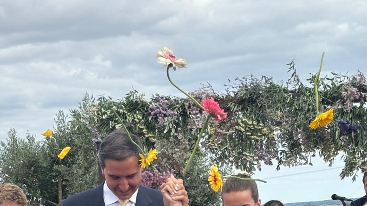 Noivos celebram casamento com flores e sorrisos.
