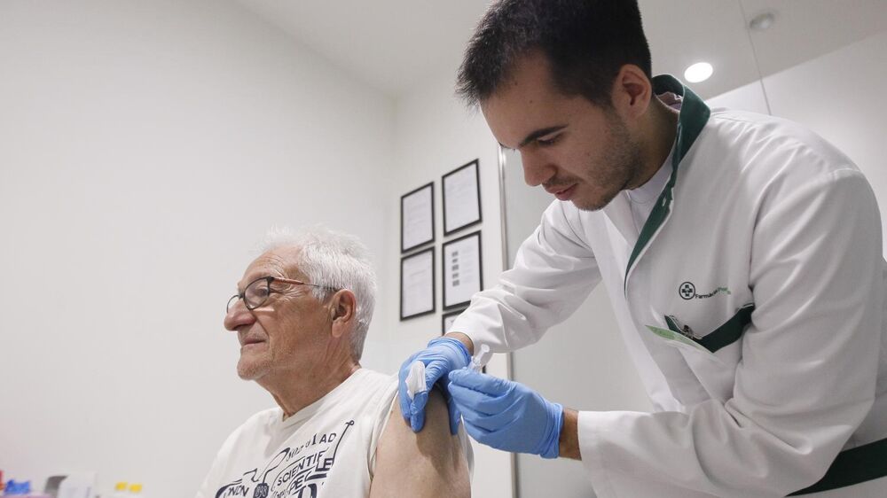 Idoso recebe vacina contra a gripe e Covid-19 numa farmácia