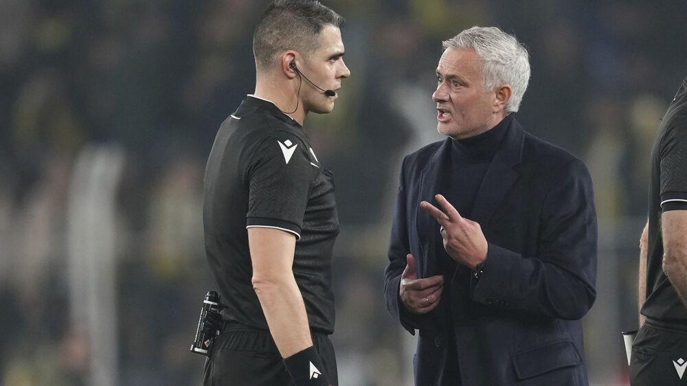 José Mourinho conversa com o árbitro Simone Sozza durante o Fenerbahçe-Lyon, na Liga Europa
