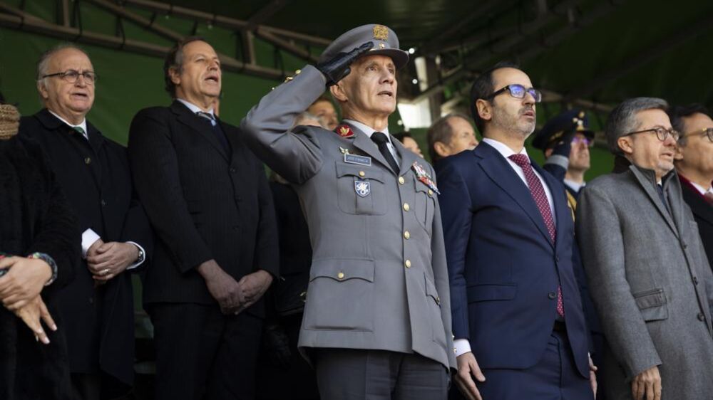 Militar saúda em cerimónia, enquanto governantes assistem