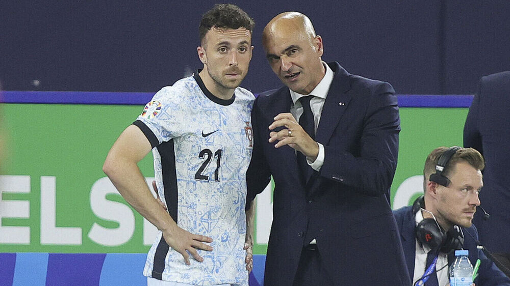 Roberto Martínez conversa com Diogo Jota durante jogo de futebol