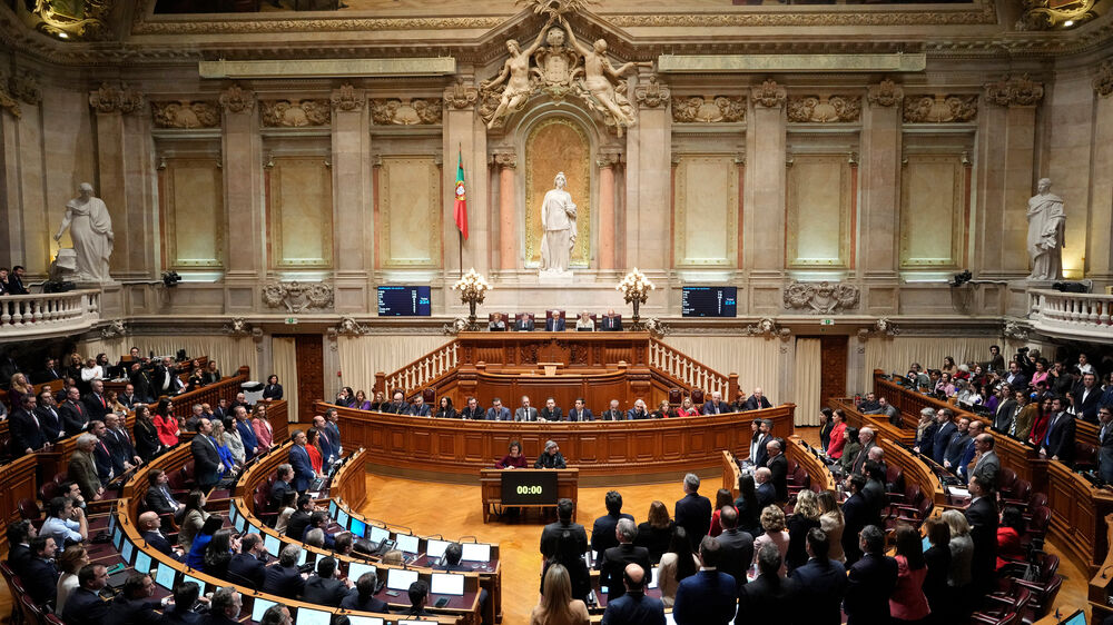 FILE - Members of opposition parties stand to vote against a government confidence motion at the Portuguese parliament in Lisbon,